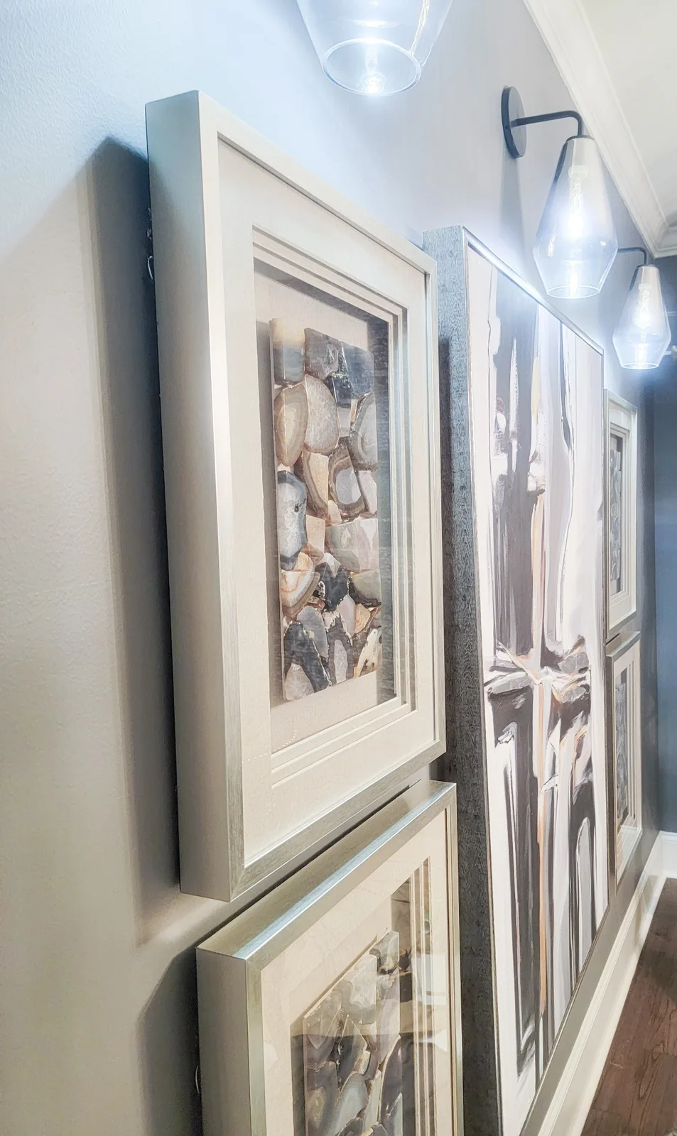 Art curation and gallery wall with framed artwork, decorative lighting, oversized abstract art, and corridor styling