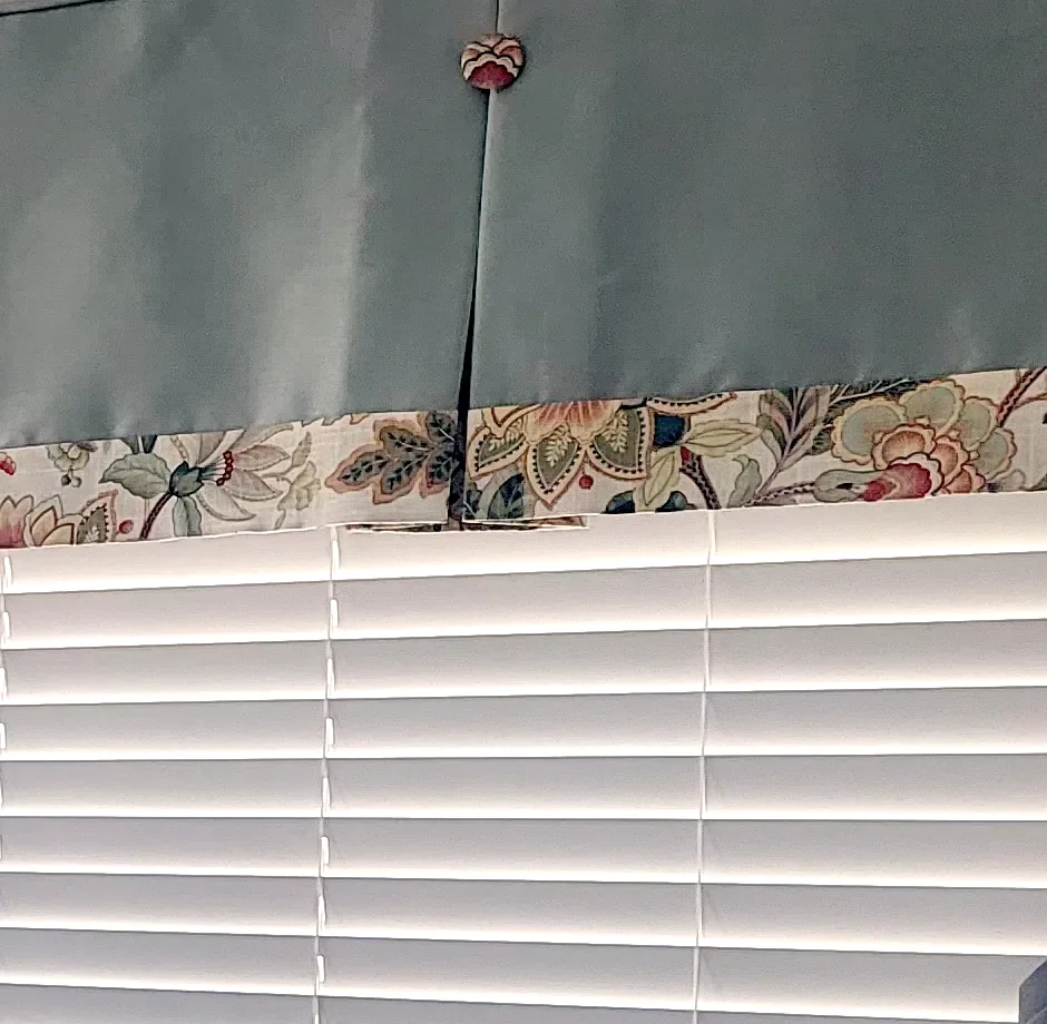 Tailored box pleat valances with button details and contrast banding over faux wood blinds