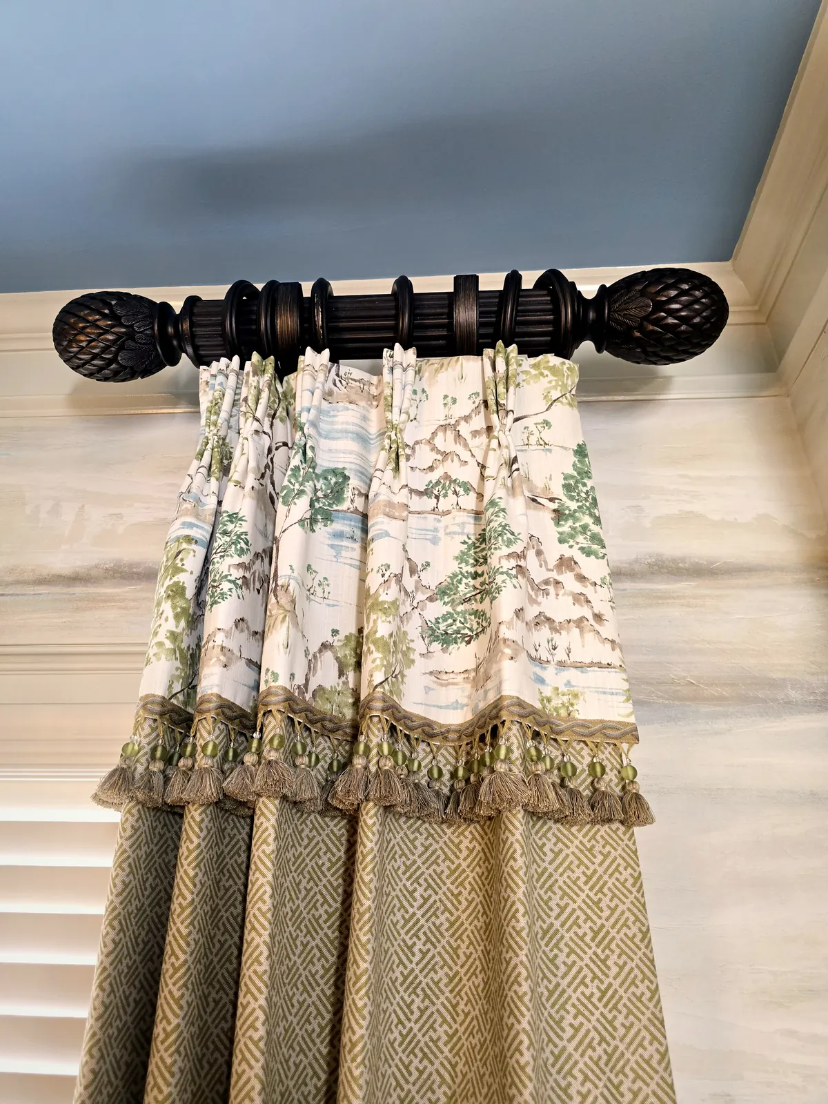 Custom drapery workroom detail with layered fabrics, beaded tassel trim, and carved finials