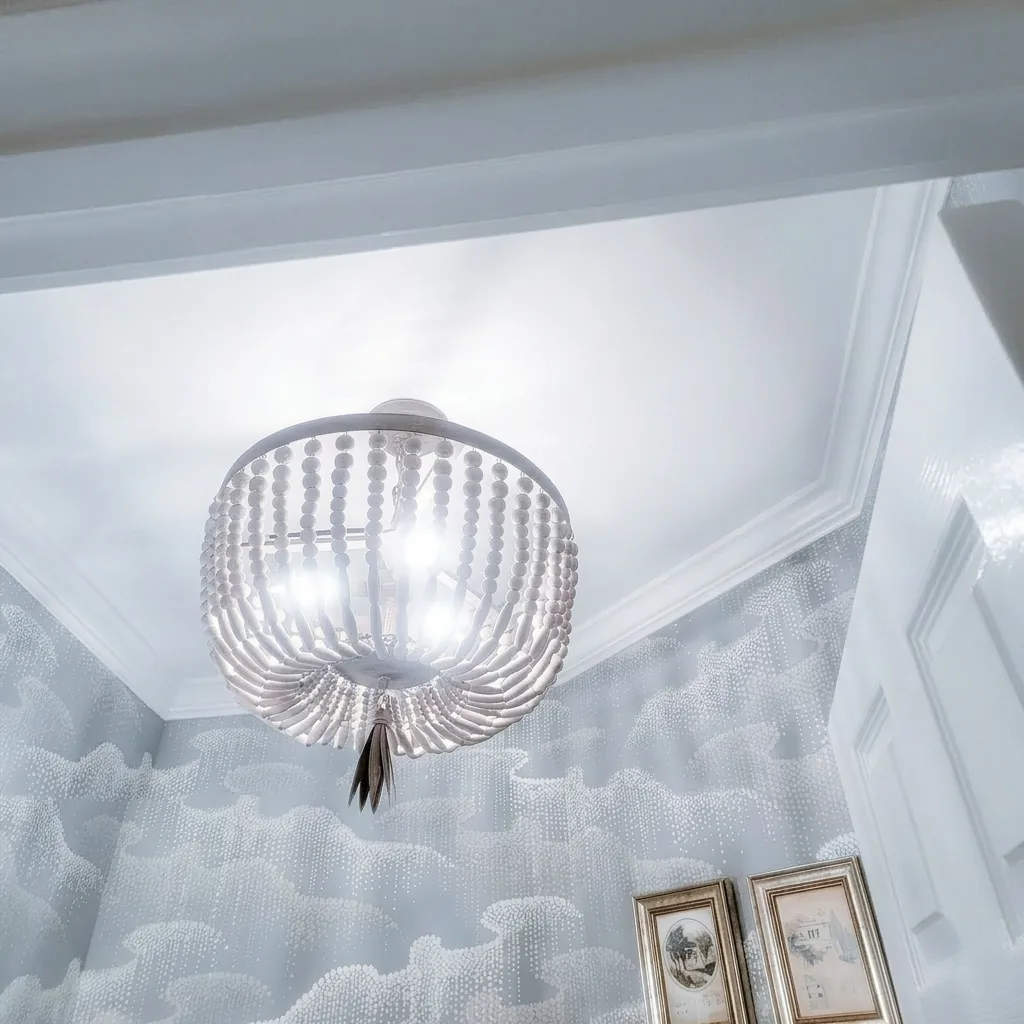 Powder room detail with designer wallcovering complemented by the customer's statement chandelier