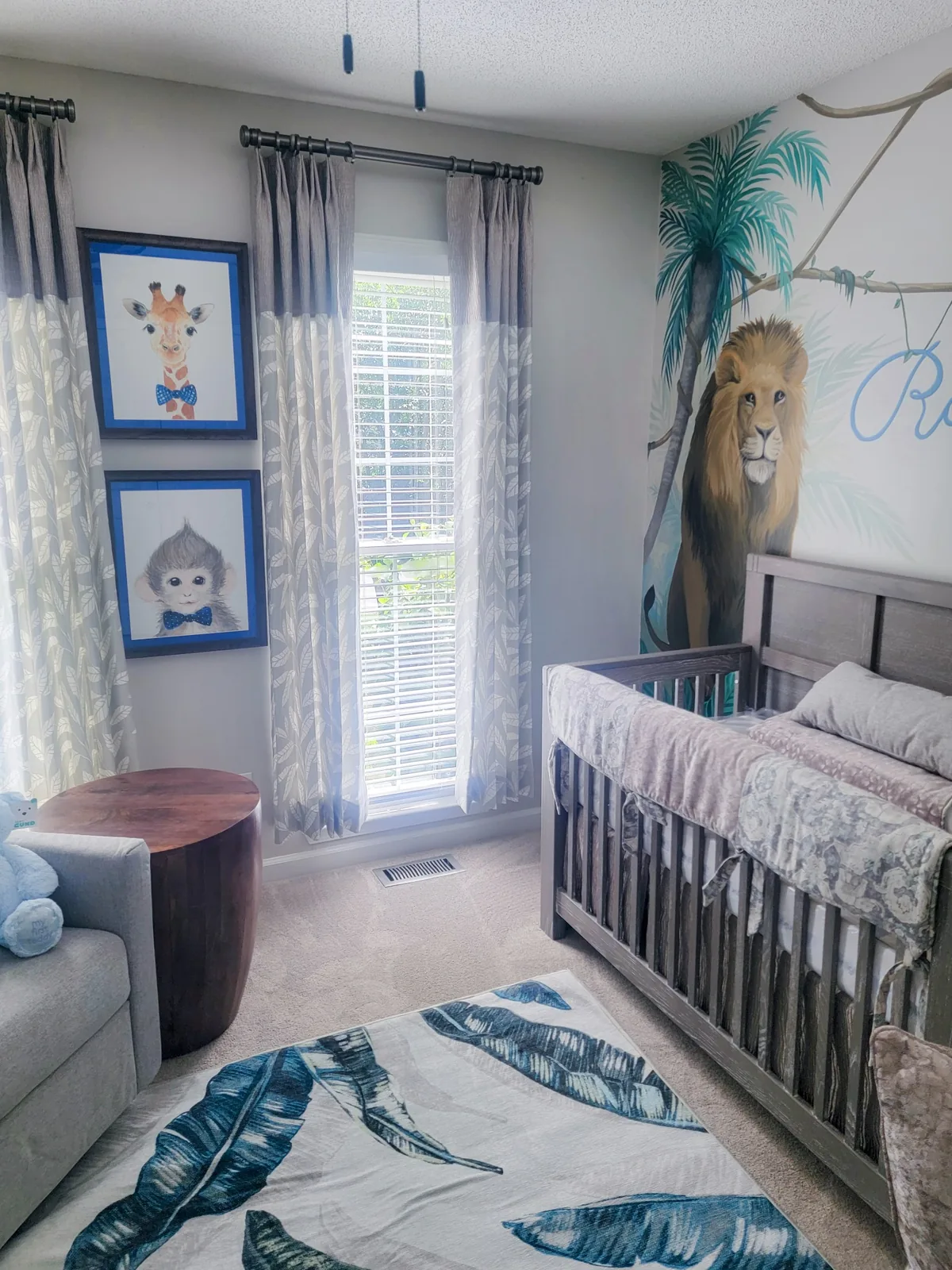 Completed safari nursery with custom mural, drapery, nursery furnishings, and botanical inspired styling
